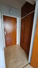 Entrance area with a wooden door and built-in wooden wardrobe.