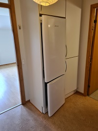 White built-in refrigerator and freezer unit in a kitchen area.