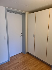 Hallway or entrance area with a white door and built-in white wardrobes.