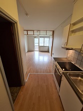 View from the kitchen looking into the main living area with a large window at the far end.